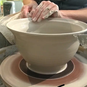 potter throwing a large bowl on the wheel, to be made into a colander.