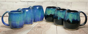 Blue World mugs, and Aurora Borealis Mugs. each one is different. northwest style coffee mug thrown pottery, with large pulled handle.