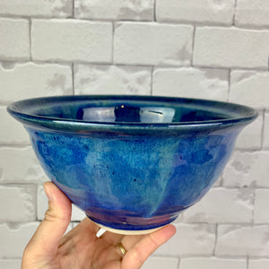 wheelthrown blue world bowl. the bowl is glazed in cobalt blue with turquoise green glaze melting down into the blue from the rim of the bowls. 