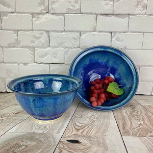 wheelthrown blue world bowl. the bowl is glazed in cobalt blue with turquoise green glaze melting down into the blue from the rim of the bowls. 