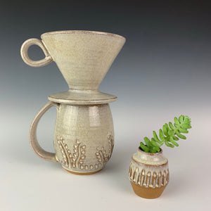 carved bud vase shown with carved mug and coffee pour over in speckled white glaze. all were thrown on the potters wheel by meredith at Fern Street Pottery