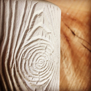 closeup of woodgrain texture in clay before it is fired
