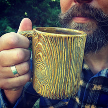 Load image into Gallery viewer, Lumberjack, bearded man drinking out of a pottery mug, carved with woodgrain to imitate tree texture. stoneware, Fern Street Pottery.