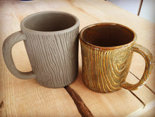 Load image into Gallery viewer, pottery mug, carved to look like woodgrain. photo of before and after firing to show the raw clay and the shrinkage amount.
