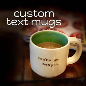 Customized text on a handcrafted, wheel  thrown coffee mug. (text reads: Custom text mugs. Mug reads: you're my people)