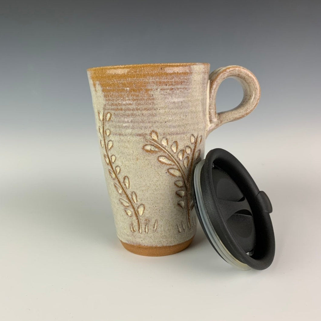 wheel thrown pottery travel mug with vine carved pattern, shown here with it's fitted lid