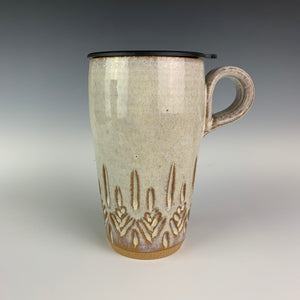 wheel thrown pottery travel mug with tree pattern carved into the bottom half of the mug. shown here with a fitted travel lid