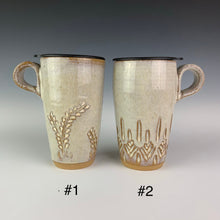 Load image into Gallery viewer, artist made Pottery travel mugs with lids. Mug #1 shows the vine pattern, mug #2 shows a carved tree-like pattern. mugs have finger loop handles so that they fit in cupholders