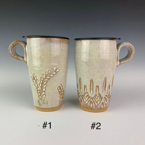 artist made Pottery travel mugs with lids. Mug #1 shows the vine pattern, mug #2 shows a carved tree-like pattern. mugs have finger loop handles so that they fit in cupholders