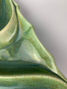 detail image of speckled green glaze on christmas tree candy dish. mossy green with brown speckles pooling where melted