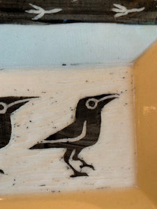 detail shot of crow carving in a pottery platter, texture is shown