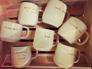 a collection of pottery mugs with customized text 