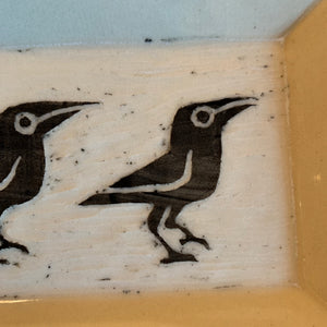 close up photo of crow platter with texture of carving showing through glaze.