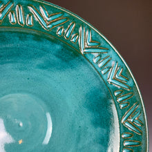 Load image into Gallery viewer, close up detail of the carved rim of a bowl. the red clay shows through the teal glaze at the edges of the carved lines.