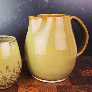 pottery pitcher in creamy brown caramel color shown here with a matching Mug