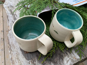 two custom text mugs with different colors inside. the mug on the right shows the mottled-green upgrade, the mug on the left has the turquoise (standard)