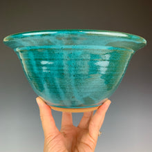 Load image into Gallery viewer, the artist holding a carved rimserving  bowl in teal.