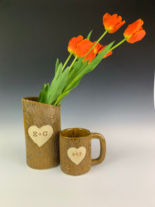 customized vase and mug shown together. pottery textured to look and feel like woodgrain, carved with initials and heart.