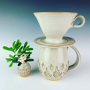 carved bud vase shown with carved mug and coffee pour over in speckled white glaze. all were thrown on the potters wheel by meredith at Fern Street Pottery